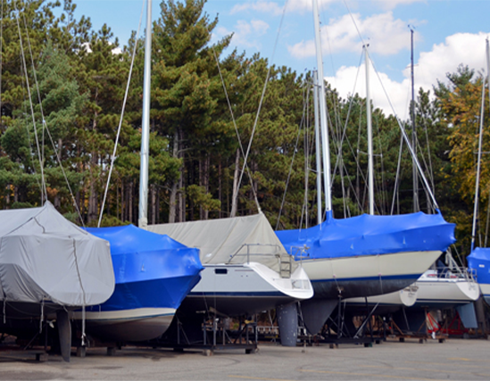 line of sail boats stored on lot with protective covers